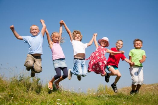Group  happy children  jumping on summer meadow against blue sky